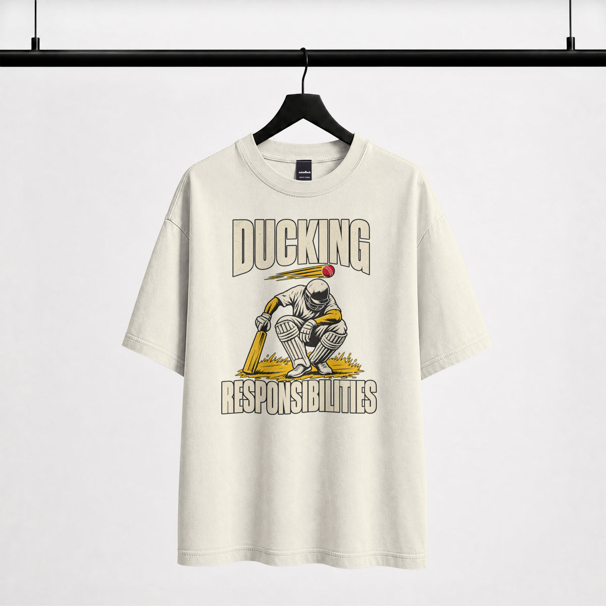 Off white Ducking Responsibilities oversized T-shirt on a hanger, cricket batter crouching under a flying red ball