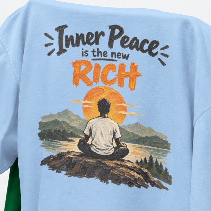 Baby Blue Inner Peace Is The New Rich print close-up, a figure meditating on a rock facing an orange sunset over mountains and a lake
