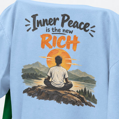 Baby Blue Inner Peace Is The New Rich print close-up, a figure meditating on a rock facing an orange sunset over mountains and a lake