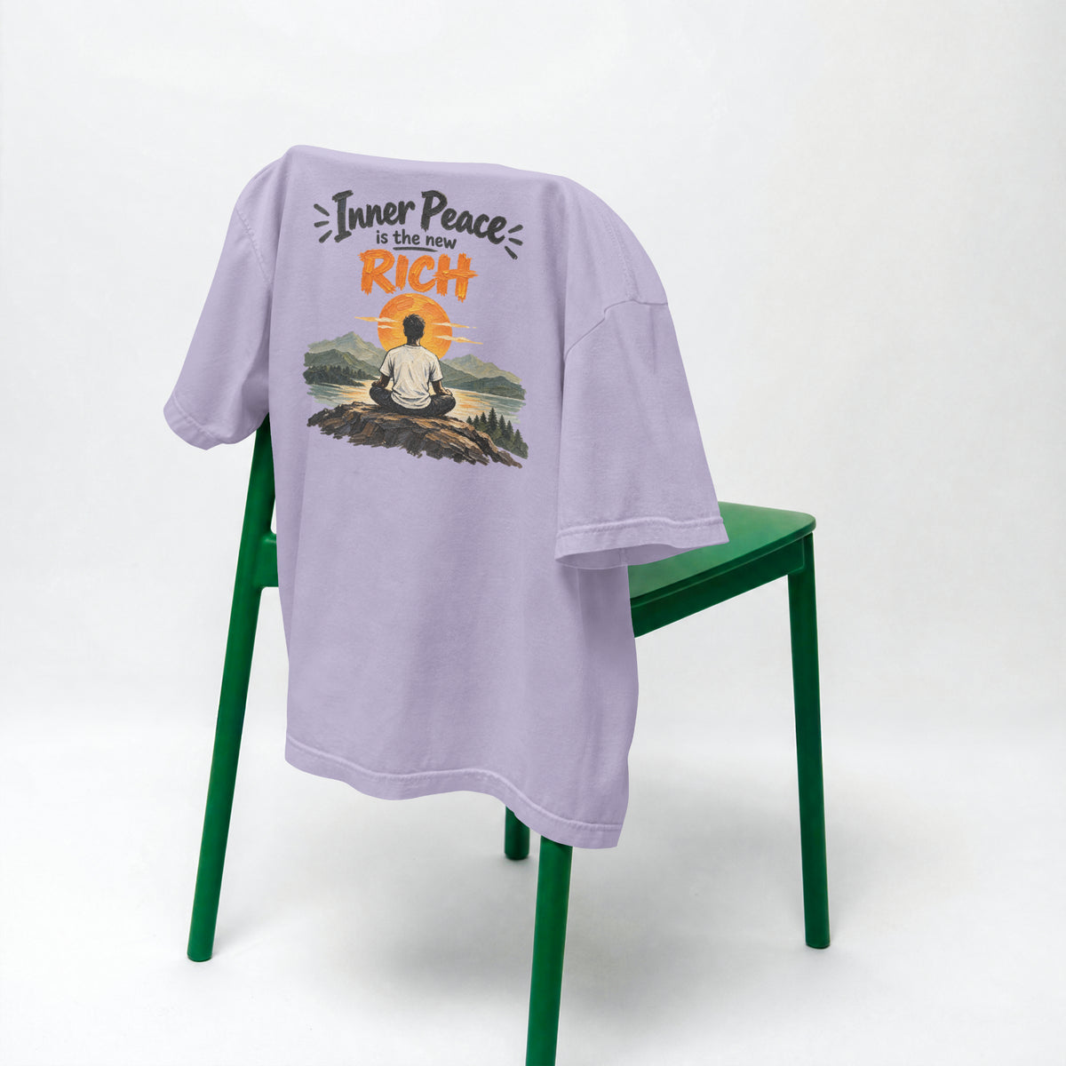 Lavender Inner Peace Is The New Rich oversized t-shirt draped over a green chair, showing the front print