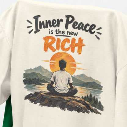 Off white Inner Peace Is The New Rich print close-up, a figure meditating on a rock facing an orange sunset over mountains and a lake