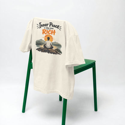 Off white Inner Peace Is The New Rich oversized t-shirt draped over a green chair, showing the front print