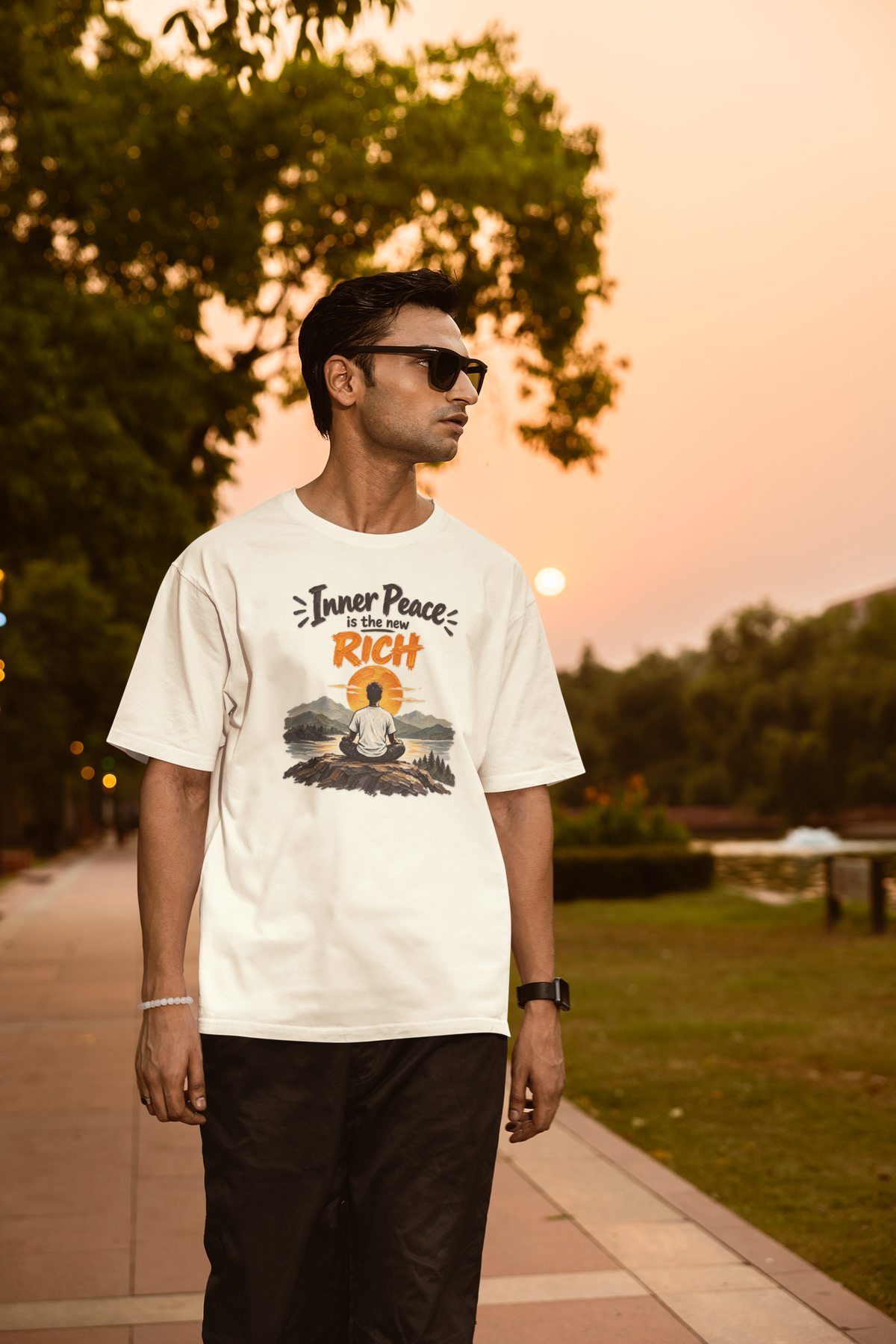 Off white Inner Peace Is The New Rich meditation unisex oversized t-shirt worn by a man at sunset, front view
