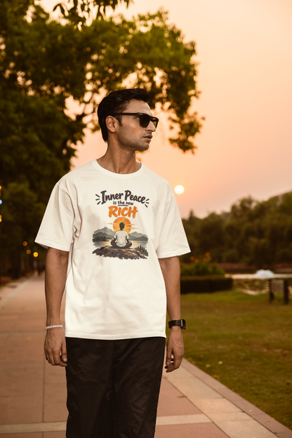 Off white Inner Peace Is The New Rich meditation unisex oversized t-shirt worn by a man at sunset, front view