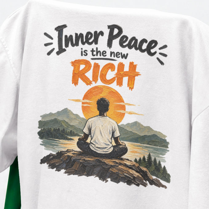 White Inner Peace Is The New Rich print close-up, a figure meditating on a rock facing an orange sunset over mountains and a lake
