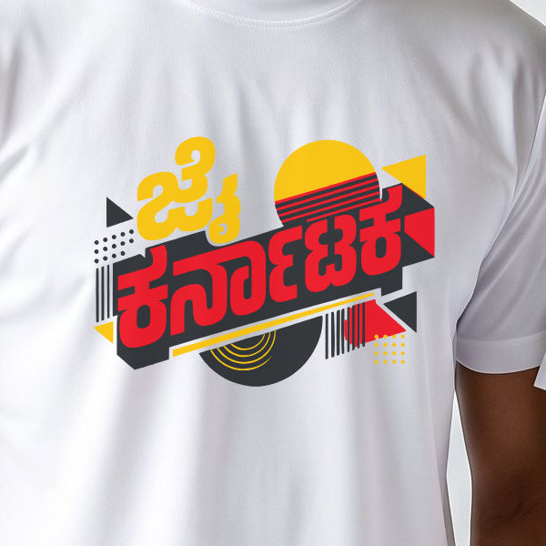 White jersey T-shirt print close-up: Jai Karnataka in yellow and red Kannada lettering on a charcoal ribbon with a retro striped sunset, red and yellow triangles, dot grids and a vinyl disc