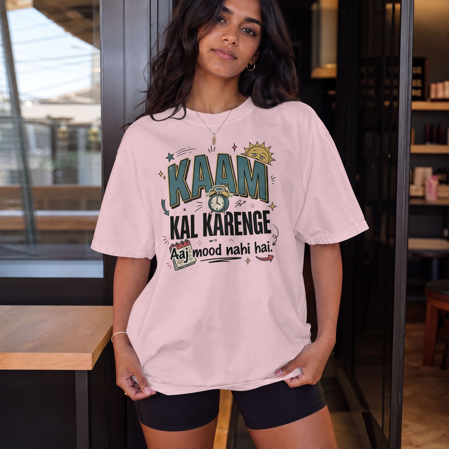 Light baby pink Nauma oversized t-shirt, model shot, featuring 'Kaam Kal Karenge' typography and doodle artwork.