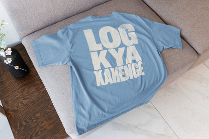 Baby Blue Log Kya Kahenge oversized t-shirt laid flat on a sofa, showing the stacked distressed cream lettering front print