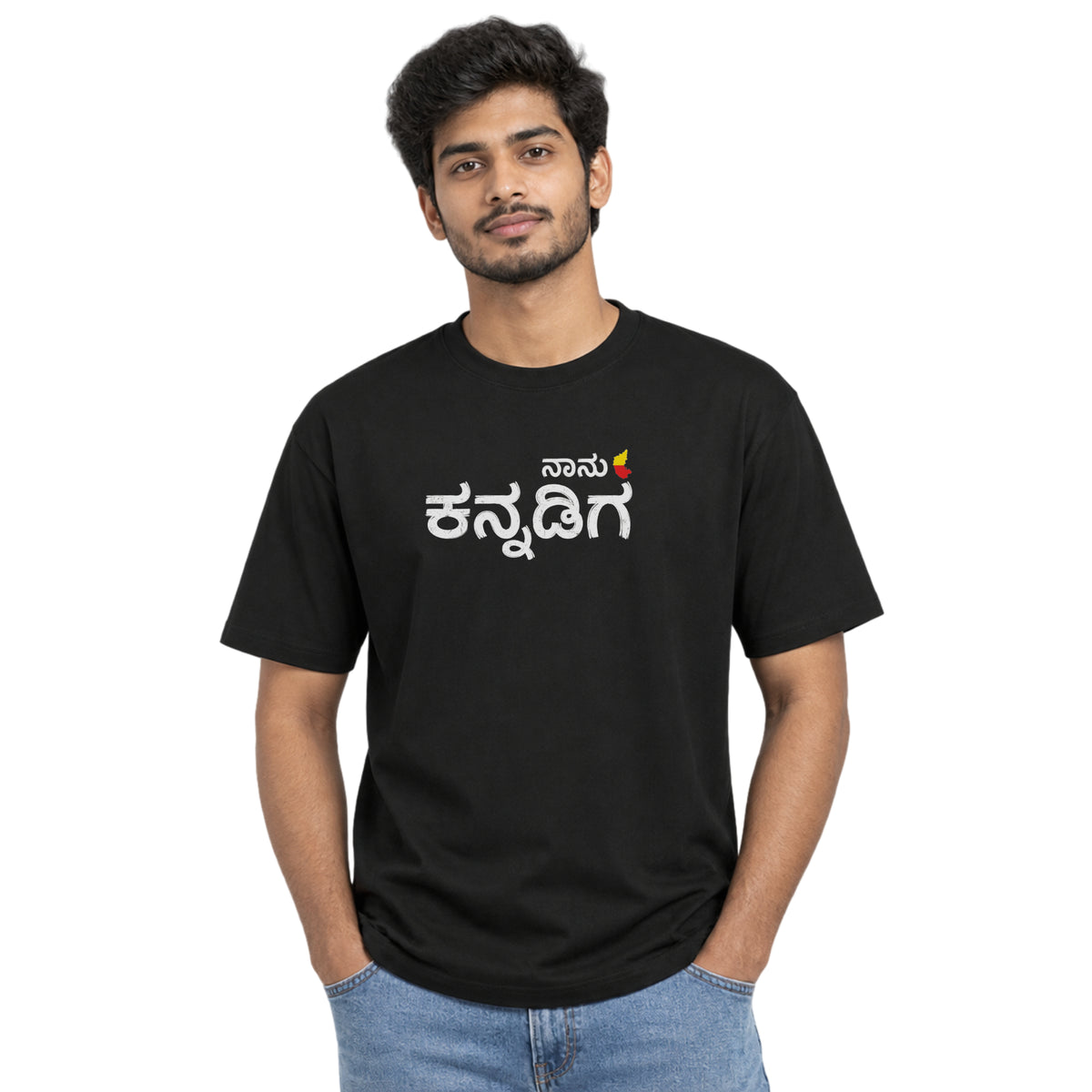 Man wearing a black crew neck T-shirt with ನಾನು ಕನ್ನಡಿಗ (Naanu Kannadiga) printed in white Kannada lettering on the chest – Nauma Kannada Rajyotsava tee