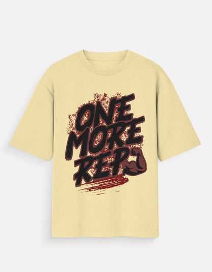 Nauma One More Rep gym graphic unisex oversized T-shirt in beige, front view with the bold hand-drawn slogan print across the chest