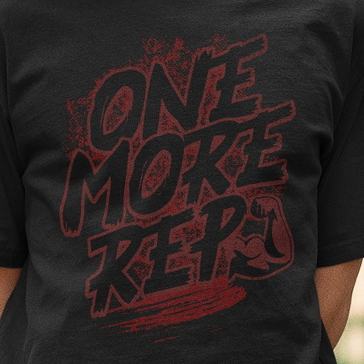 Close-up of the One More Rep print on the black Nauma oversized T-shirt, lettering reading tonal in deep red on black