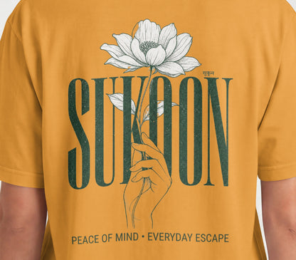 Closeup of Nauma Sukoon oversized t-shirt back print in golden yellow with lotus flower and hand illustration