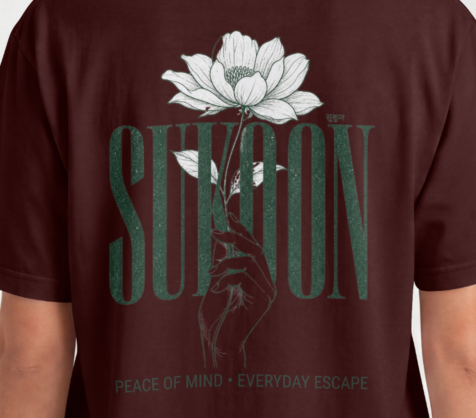 Closeup of Nauma Sukoon oversized t-shirt back print in maroon with lotus flower and hand illustration