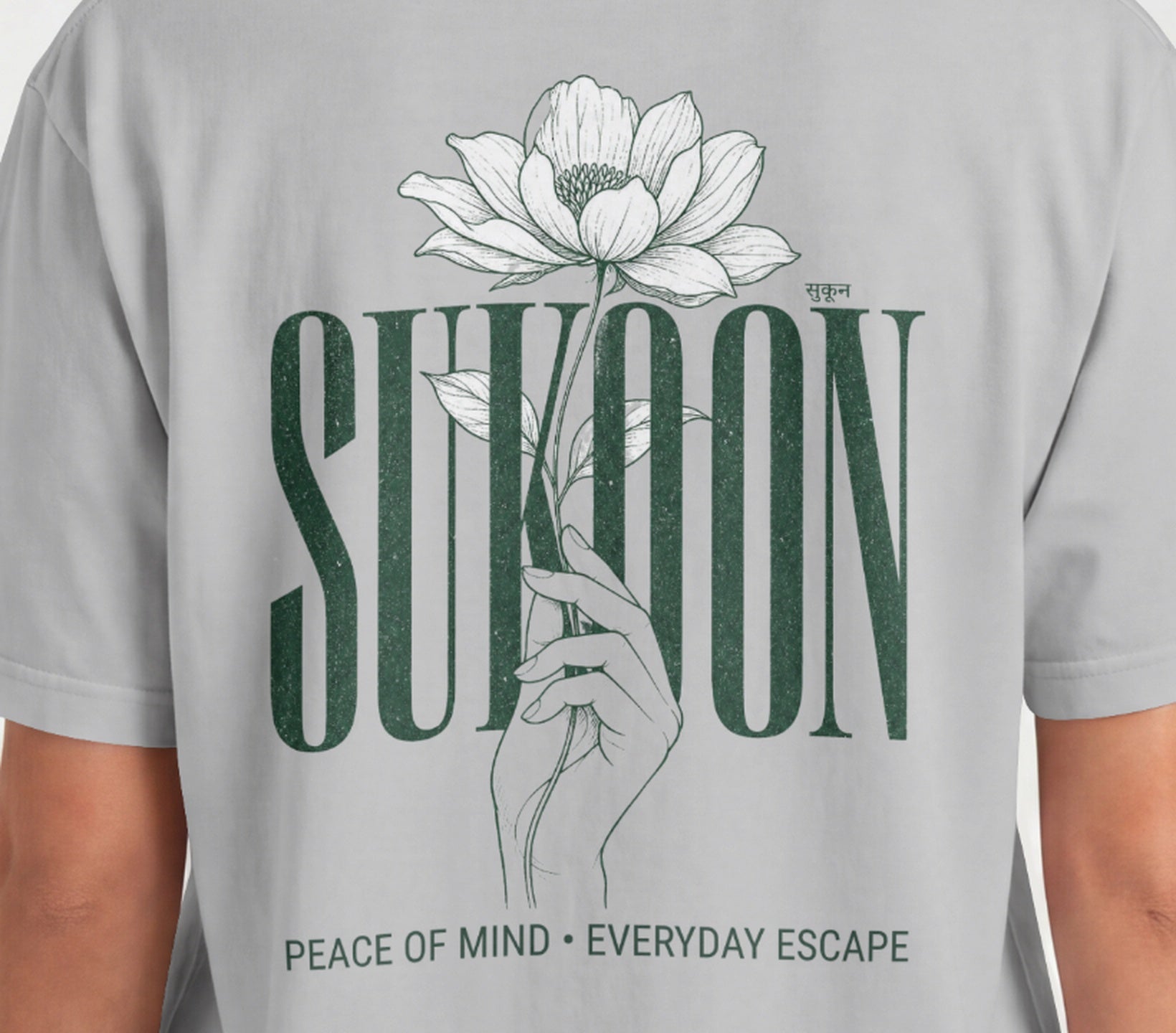 Closeup of Nauma Sukoon oversized t-shirt back print in melange grey with lotus flower and hand illustration