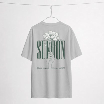 Nauma Sukoon oversized t-shirt in melange grey on a hanger, back print with lotus flower and hand illustration
