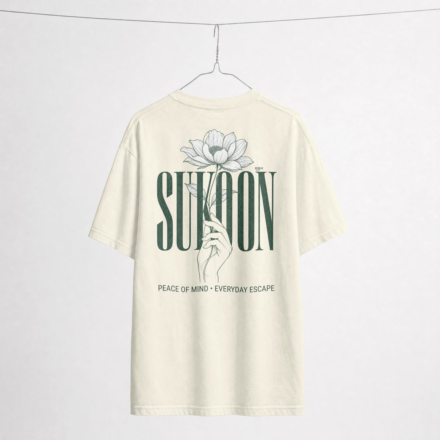 Nauma Sukoon oversized t-shirt in off white on a hanger, back print with lotus flower and hand illustration