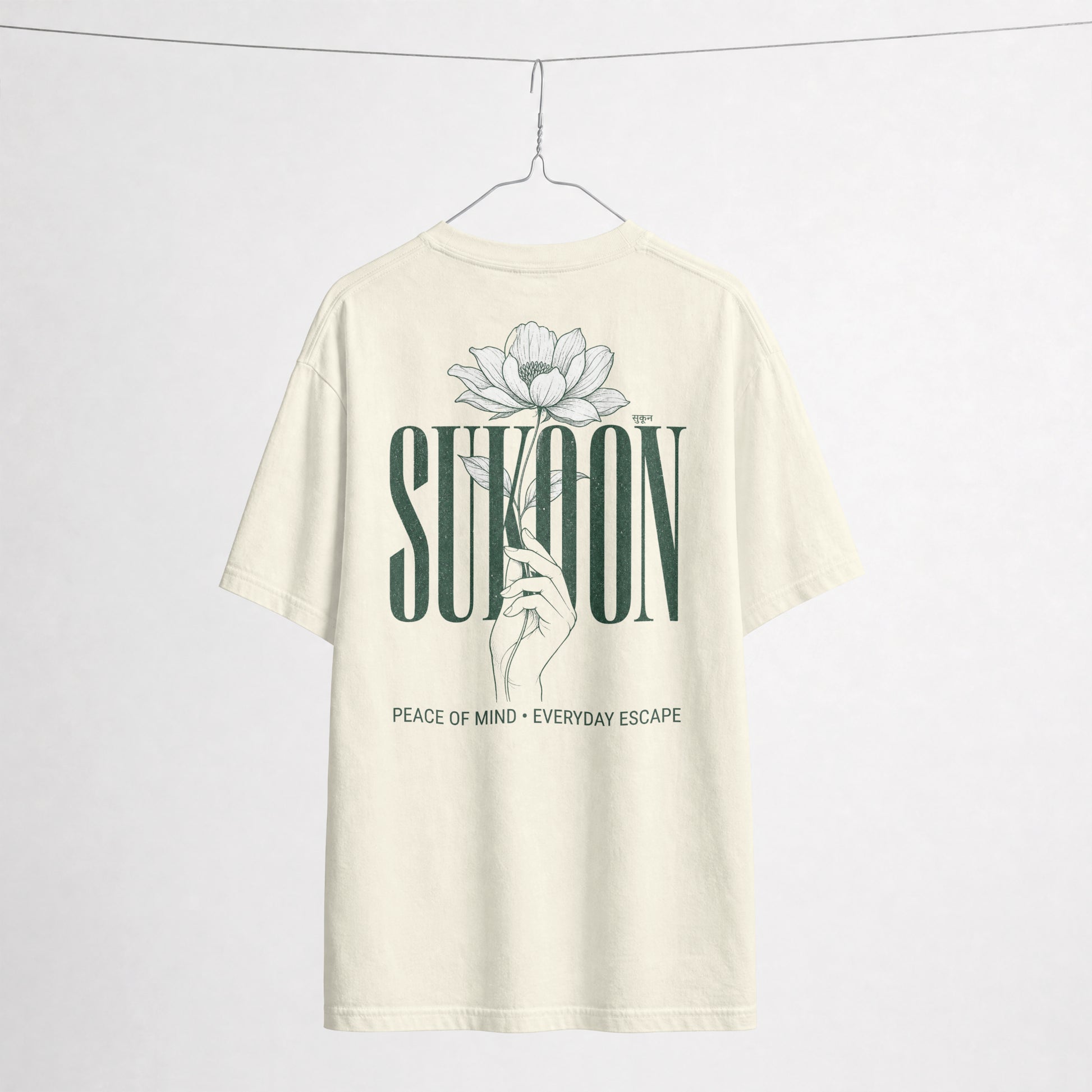 Nauma Sukoon oversized t-shirt in off white on a hanger, back print with lotus flower and hand illustration