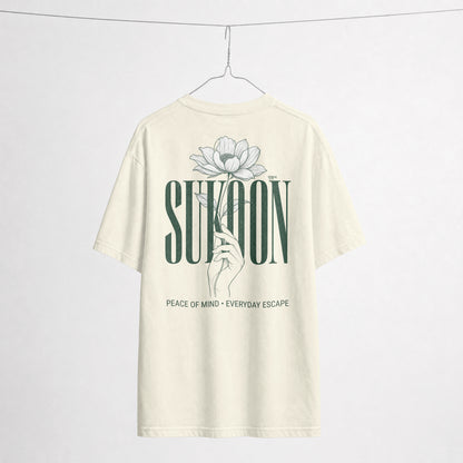 Nauma Sukoon oversized t-shirt in off white on a hanger, back print with lotus flower and hand illustration
