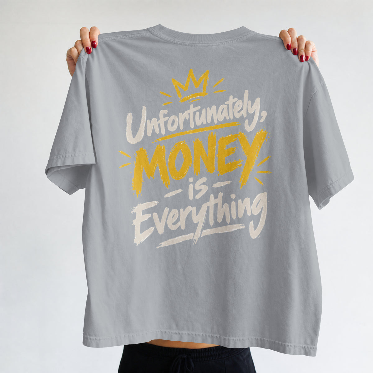 Melange Grey Unfortunately Money Is Everything oversized T-shirt held up to show the light back slogan print with MONEY in mustard yellow