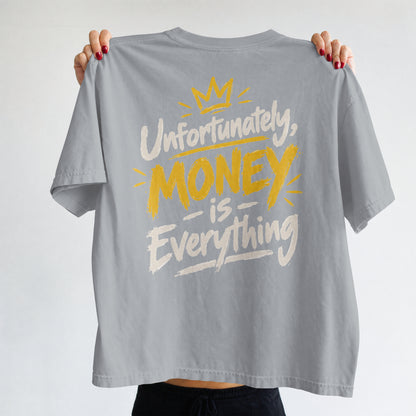 Melange Grey Unfortunately Money Is Everything oversized T-shirt held up to show the light back slogan print with MONEY in mustard yellow