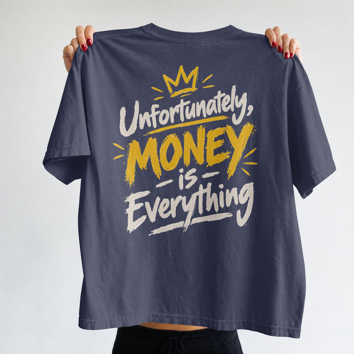 Navy Blue Unfortunately Money Is Everything oversized T-shirt held up to show the light back slogan print with MONEY in mustard yellow