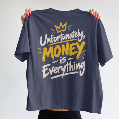 Navy Blue Unfortunately Money Is Everything oversized T-shirt held up to show the light back slogan print with MONEY in mustard yellow