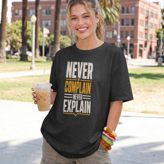 Black unisex oversized drop shoulder t-shirt with "Never Complain Never Explain" minimalist print, 100% premium cotton streetwear India.
