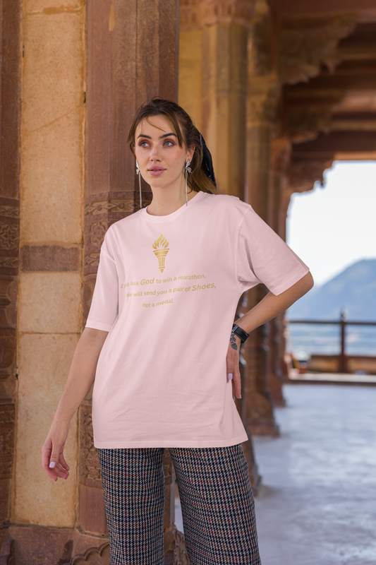 Woman styling a Baby light pink baggy-fit drop-shoulder t-shirt with a gold torch print and inspirational message.
